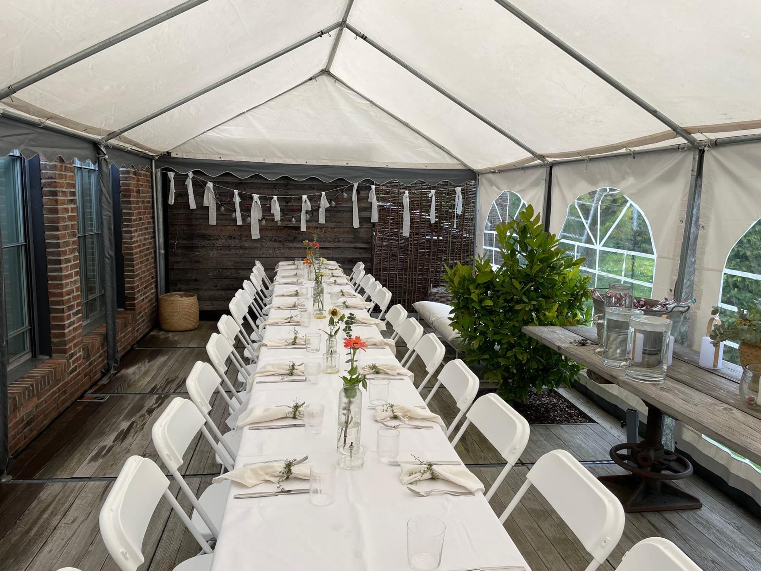 Festzelt mit festlich gedeckter Tafel und Pflanzen